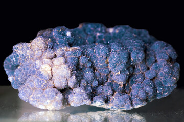 Purple blue mineral creedite on a black background. Calcium aluminum sulfate fluorohydroxide