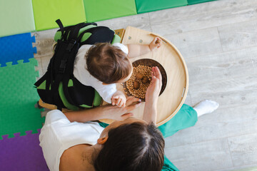 Top view of sensory and physical rehabilitation session of small male child standing in a...