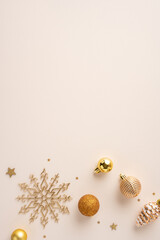 Festive gold Christmas vertical decorations including baubles and a snowflake on a neutral beige surface creating a sophisticated holiday atmosphere