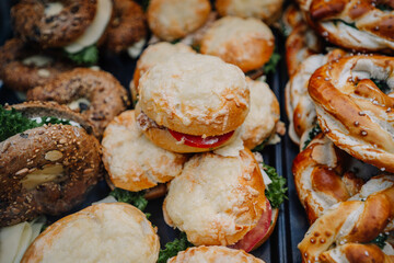 Munich, Germany - September 13, 2024 - A variety of Bavarian bread rolls topped with cheese, stuffed with lettuce, tomato, and meats, alongside seeded bagels and pretzels.