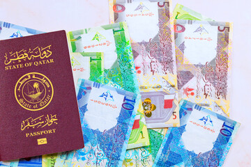 State of Qatar passport with is Qatari banknotes currency Riyals cash various nominal