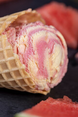 watermelon red ice cream with slices of ripe red watermelon, red watermelon and ice cream on a black slate board close-up