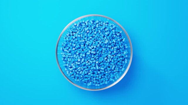 Rotating glass bowl with blue plastic polypropylene granules, masterbatch polymer grain on blue backdrop. HDPE or PVC resin pellets. 3d render animation