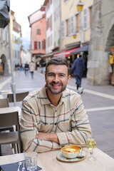 Handsome man eating in European cafe terrace 