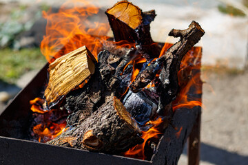 A fire burns in a barbecue grill for cooking shashlik