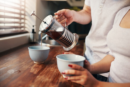 Hands, french press and coffee for couple in kitchen with breakfast, bonding and start morning at apartment. People, drink and together with mug, love and connection with plunger in modern house