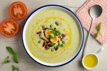 Cream of green beans with Iberian ham and quail egg. Top view table with  decoration.