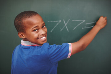 Math, student and portrait at chalkboard in classroom with problem solving, education or learning development. Scholarship, black boy or answer question with multiplication or number lesson at school - Powered by Adobe