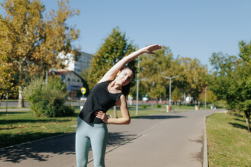 Young Sporty Woman Doing Physical Exercises in the Park on a Sunny Day