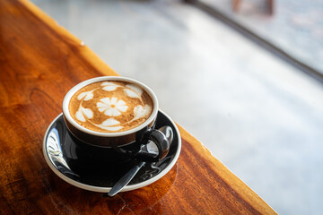 Hot coffee latte with latte art milk foam in cup mug on wood desk on top view. As breakfast In a coffee shop at the cafe,during business work concept,vintage style
