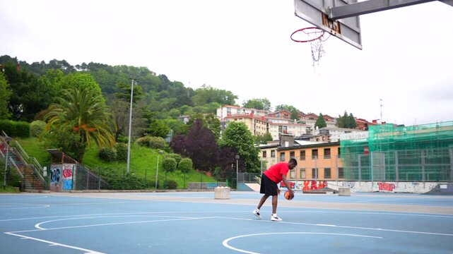 Side view of an african basketball player practicing free throws at outdoor sports court