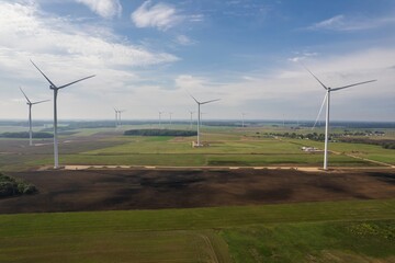 Wind turbines farm over green field and blue sky in Lithuania, Europe