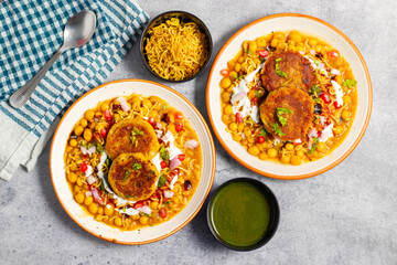 Dabeli is a spicy Indian street food made with a potato filling, tamarind chutney, and sev, served in a bun.