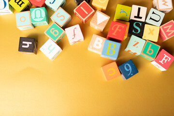 Colorful alphabet blocks scattered on a yellow background Learning is fun