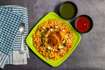 Dabeli is a spicy Indian street food made with a potato filling, tamarind chutney, and sev, served in a bun.