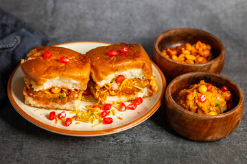 Dabeli is a spicy Indian street food made with a potato filling, tamarind chutney, and sev, served in a bun.