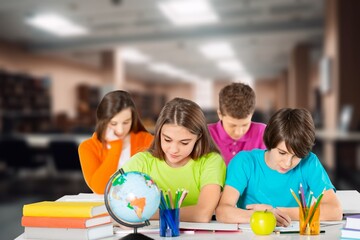 School children students sit at desks, studying