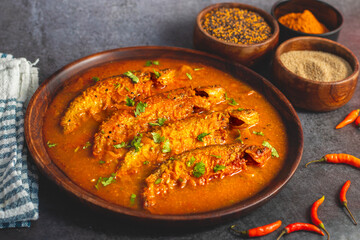 A rich, spicy Bengali dish featuring soft pabda fish simmered in a flavorful mustard-tomato gravy.