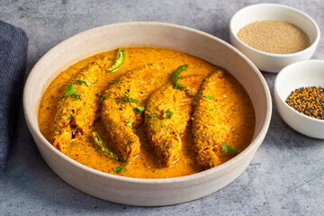 A rich, spicy Bengali dish featuring soft pabda fish simmered in a flavorful mustard-tomato gravy.