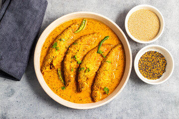 A rich, spicy Bengali dish featuring soft pabda fish simmered in a flavorful mustard-tomato gravy.