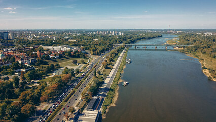 Naklejka premium Aerial view of the Vistula River and greenery along the banks in Warsaw, showcasing urban life and nature on a sunny day