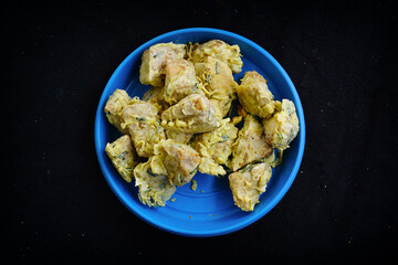 A close-up view shows delicious Indonesian fried tofu Sumpel pieces with green onion batter in a blue bowl ready to eat.