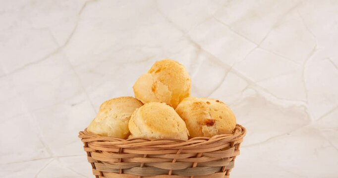 Minas Gerais cheese bread, hot, ina  wooden basket in clean brown background