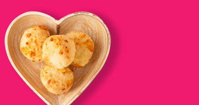 Minas Gerais cheese bread balls in a heart shapped bowl and clean background 
