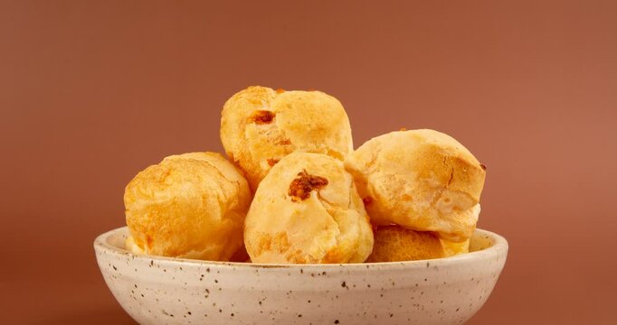Minas Gerais cheese bread balls in a bowl and clean background front view
