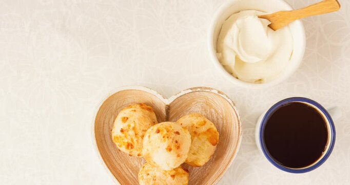 Minas Gerais cheese bread balls in a heart shapped bowl and clean background 
