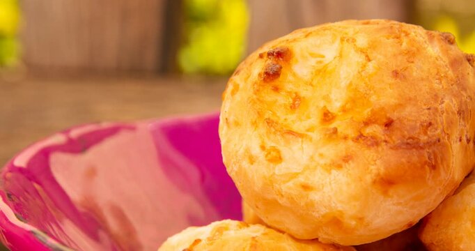 Minas Gerais cheese bread, hot, in a  wooden basket in clean garden background