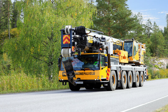 Liebherr LTM 5-axle mobile crane driving along highway on a day of early autumn. Copy space. 