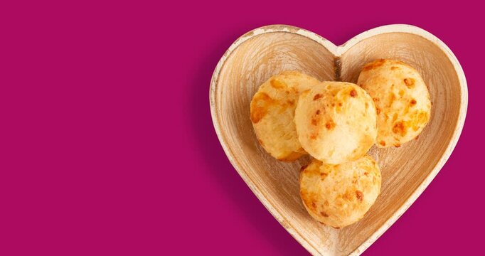 Minas Gerais cheese bread balls in a heart shapped bowl and clean background 
