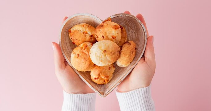 Minas Gerais cheese bread balls in a heart shapped bowl and clean background 
