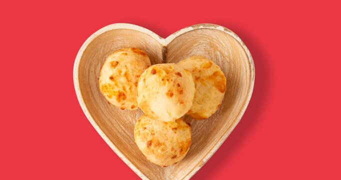 Minas Gerais cheese bread balls in a heart shapped bowl and clean background 
