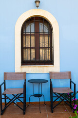 Table and chairs in front of the blue coloured historic house.