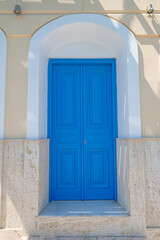 The blue-coloured door of a historic house.