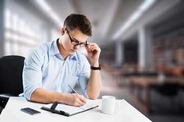 Happy teenager guy studying with notebook