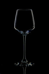 Empty wine glass on table against black background, space for text
