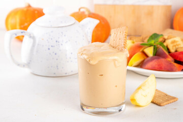 Pumpkin Fluff, Pumpkin spice mousse dip with cookies, fruits, crackers on appetizer serving board for fall, thanksgiving party. Homemade pumpkin puree mixed with vanilla pudding, buttercream, spices