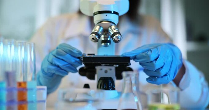 Scientist using microscopy glass setup in laboratory