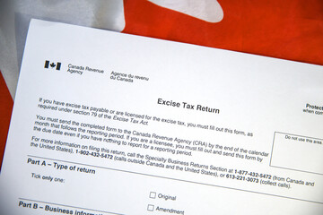 Excise Tax Return form with Canadian flag in the backdrop. Canada excise tax return background concept