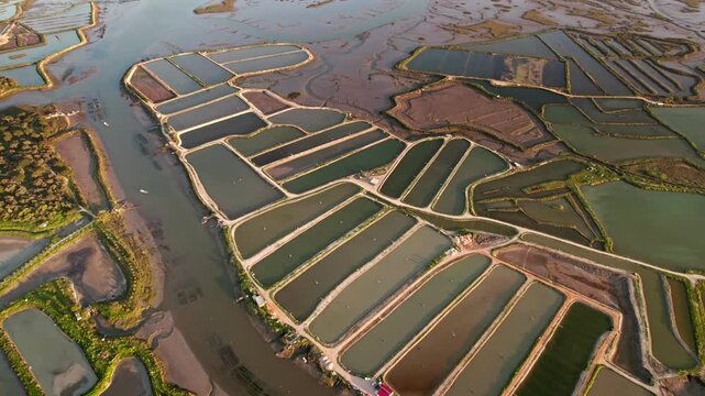 A stunning aerial shot of vibrant salt pans used for salt extraction, showcasing the geometric beauty and industrial symmetry of the saline landscape.