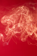 Curls of smoke on a red background