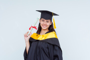 A smiling female graduate in cap and gown proudly holds her diploma. Bachelor of Science graduate,...