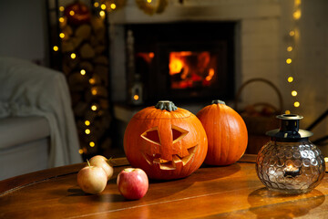 Halloween pumpkin jack-o'-lantern on old wooden table with burning fire place background in a...