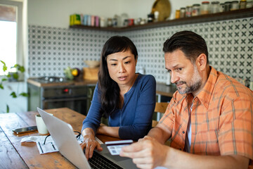 Couple managing finances online using credit card