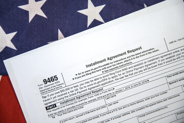 USA installment agreement request form paper placed on the American flag with copy space, background