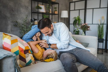 adult single father hold and tickle daughter at home