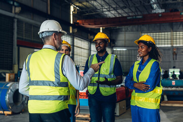 The Manager are taking a safety briefing before work. Implementation of safety culture at Factory. Factory Meeting:  Chief Engineer Talking to Colleagues Before Work Day in Heavy Industry